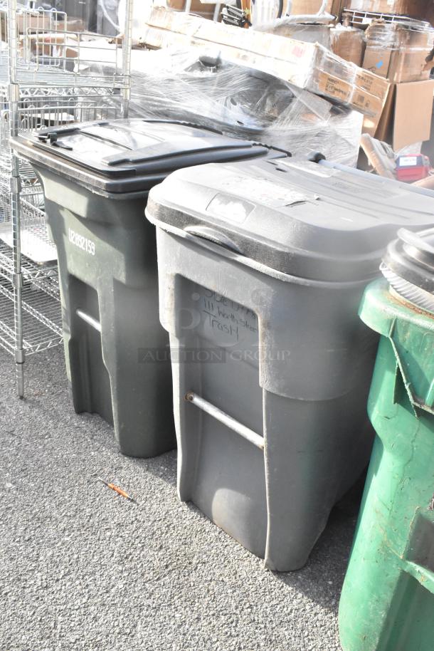 Two large poly trash cans, used condition, with lids. One marked "Side Only, 111 Worth Street, Trash." Bids doubled.