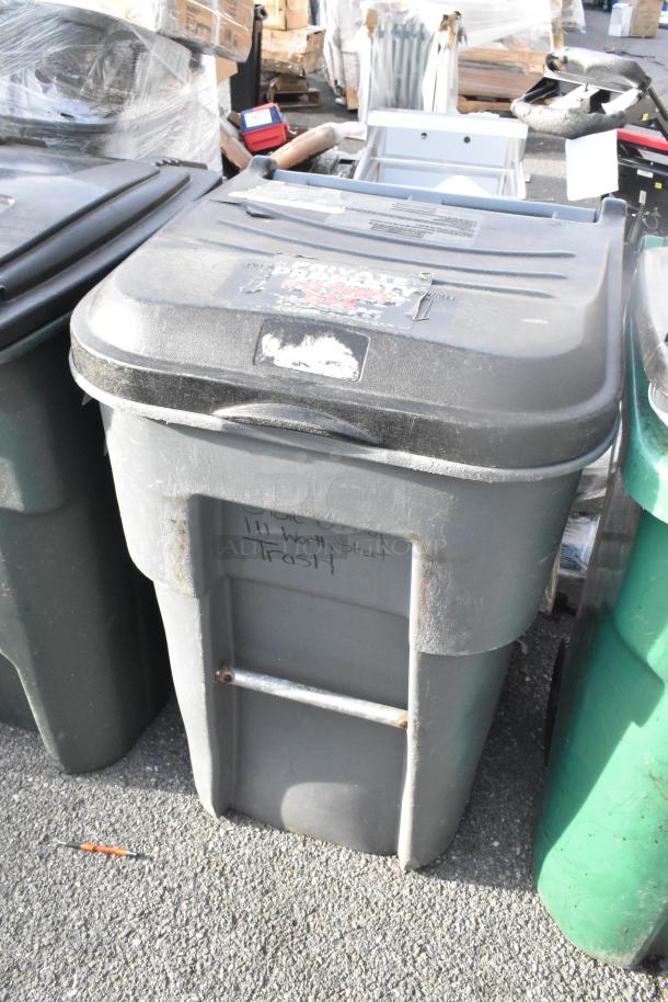 Two poly trash cans in used condition, marked "111 Worth Street Trash" on the front, placed outdoors.