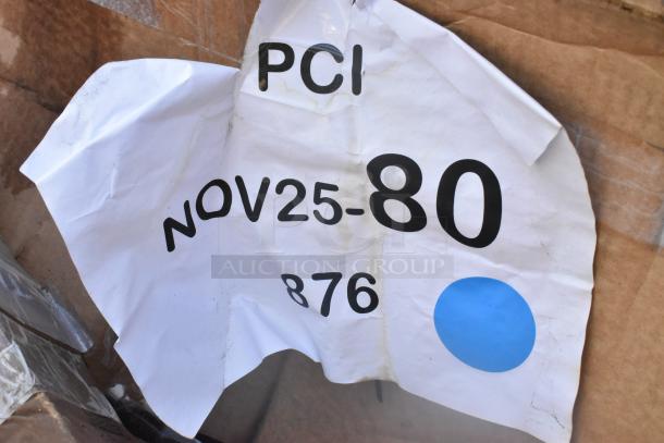 Wrinkled label on cardboard with "PCI NOV25-80 876" and a blue circle, possibly indicating auction lot details.