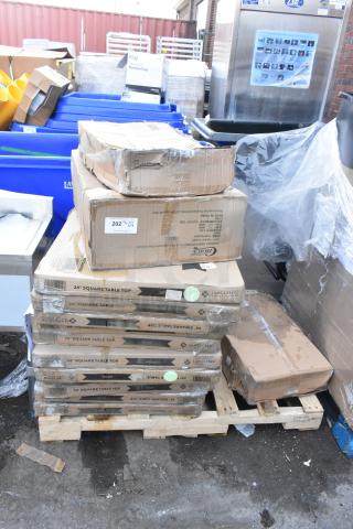 Stack of boxed items including Choice food pan carriers, Lancaster table tops, and fry pans on pallet. New condition.