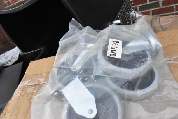 Packaged wheels labeled "BS10NB" on cardboard, part of a lot with foam bowls and trash cans. New, ready for auction.