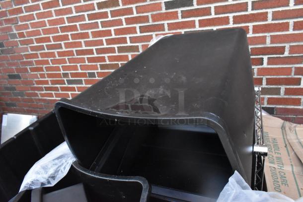 Black poly trash cans on display, part of a lot including DART 12BWWQR foam bowls and DW CP-1075550 pet cake base. New, scratch and dent condition.