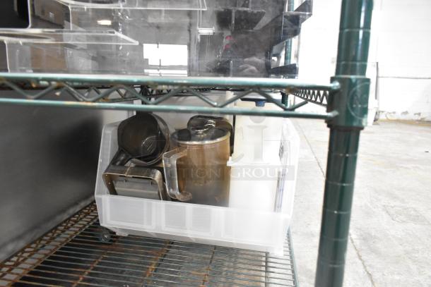Two-tier lot of poly lid dispensers and bin on a metal shelf, featuring various kitchen containers and utensils.