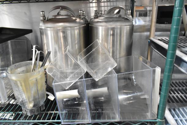 Two-tier lot with poly bins, lids, hoppers, and metal kegs. Visible wear, ideal for storage and industrial use.