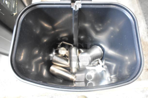 Two black poly trash cans with silver hardware inside, in used condition.