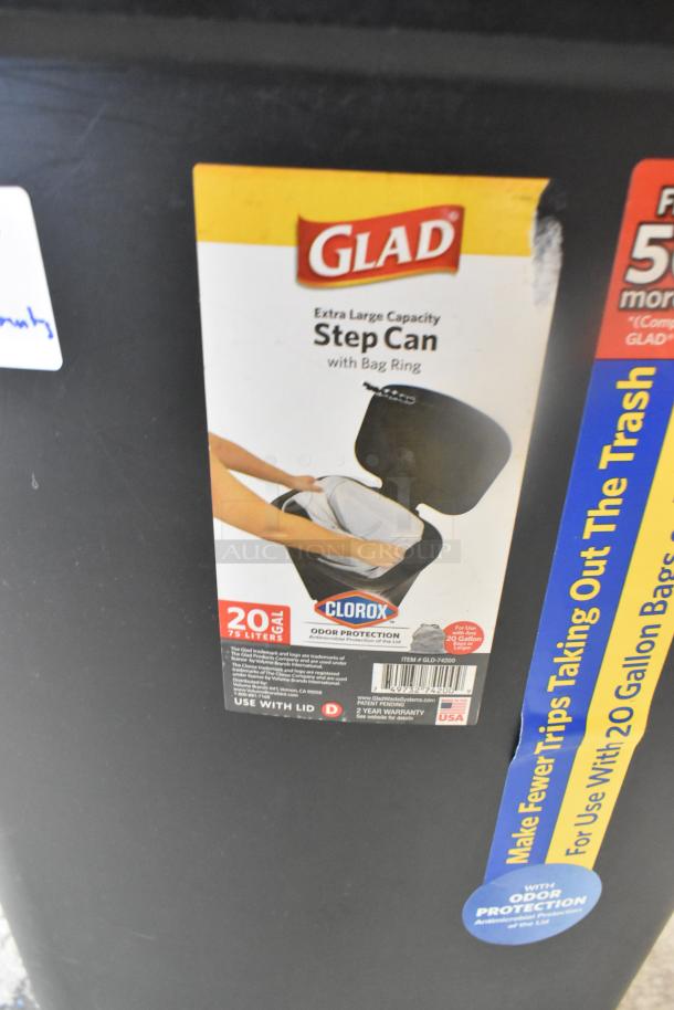 Two black Glad poly trash cans with step can design, 20-gallon capacity, Clorox odor protection, and extra-large capacity label.