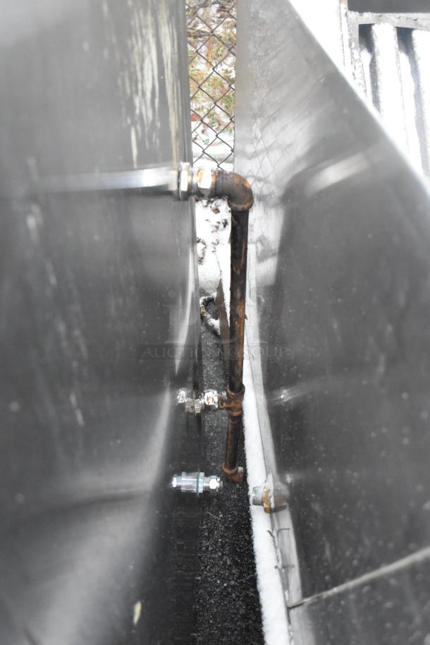 This image shows the side view of an 8' stainless steel commercial grease hood with filters and lights, highlighting its metal connections and slight rust on a pipe. The hood is suitable for restaurant use.