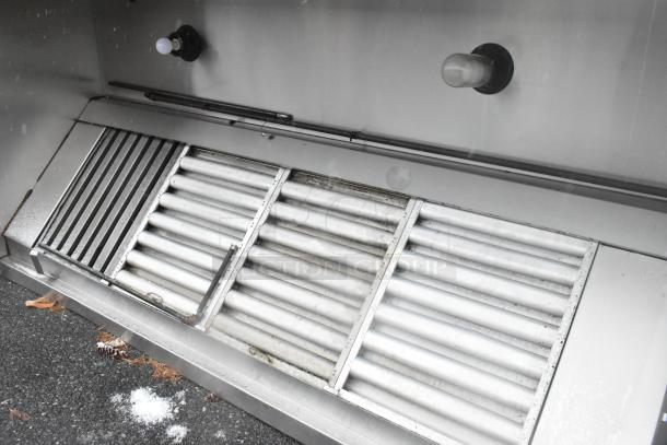 8' stainless steel commercial grease hood with filters and lights, in good condition, featuring two visible bulbs.