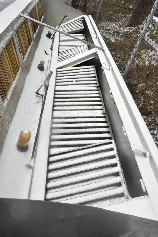 14.5' stainless steel commercial return air grease hood with filters and lights, shown in outdoor setting. Snow-covered.