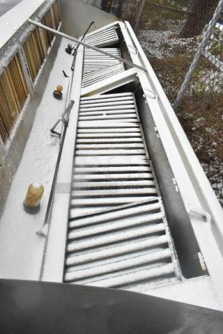 14.5' stainless steel commercial return air grease hood with filters and lights, shown in outdoor setting. Snow-covered.