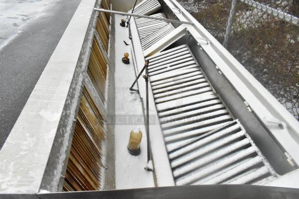 14.5' stainless steel commercial return air grease hood with filters and lights, in used condition, outdoor setting.