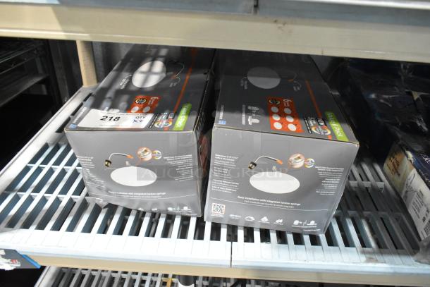 Two Halo LT56079FS1EWHR6PK LED recessed downlight boxes on a shelf. New condition, six-pack, 6-inch white fixtures.