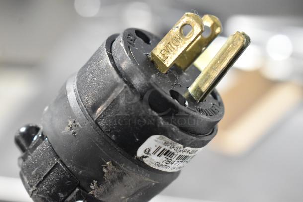 Power plug for La Spaziale espresso machine, showing wear. Label indicates model details and origin.