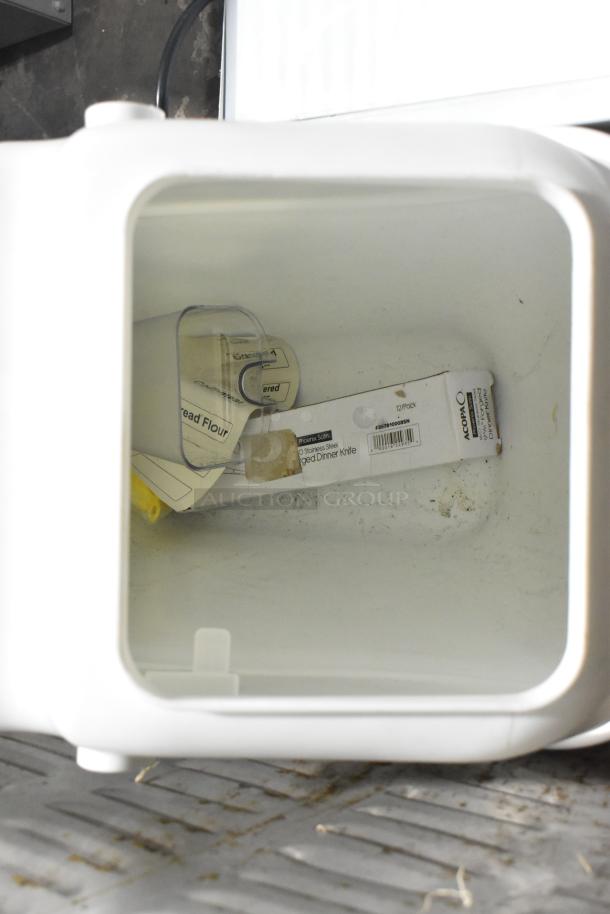 White poly ingredient bin, open, interior view showing scoops and a knife box. Sturdy plastic, slightly used condition.