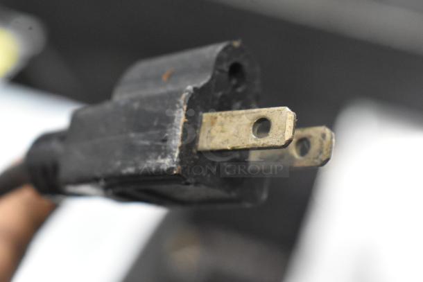 Close-up image of a black electrical plug for JuiceMatic MJ40 commercial citrus juicer. Plug shows some wear.