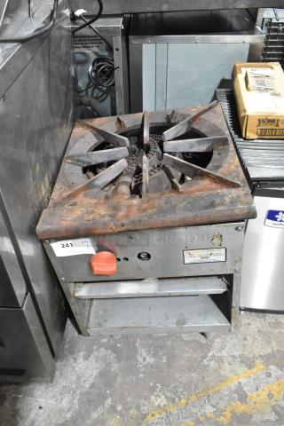Stainless steel commercial gas single burner stock pot range, worn condition, with visible rust and a control knob.