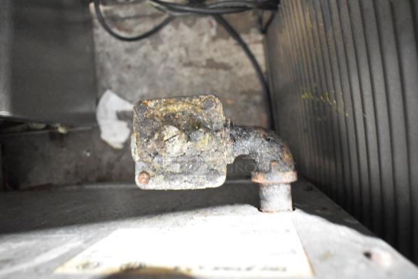 Stainless steel commercial gas burner component, showing signs of wear and discoloration, essential part of a stock pot range.