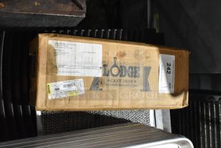 Box of 4 Lodge Cast Iron Cornstick Pans, brand new, with visible branding and shipping labels.