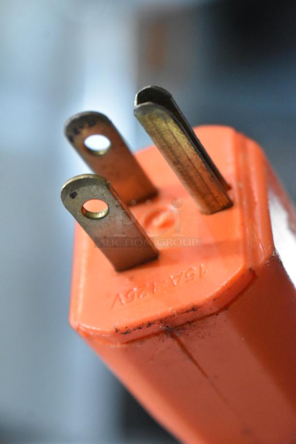 Close-up of an orange electrical plug labeled "15A 125V," possibly from Manitowoc IY0324A-161 ice machine, showing wear.