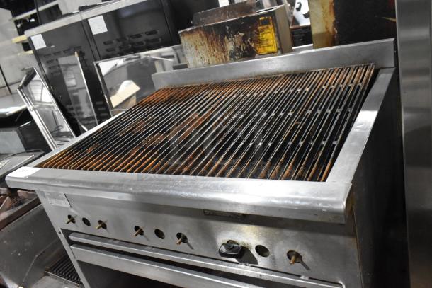 Rankin Delux RB-836 stainless steel charbroiler grill, natural gas, with under shelf and commercial casters, visible wear.