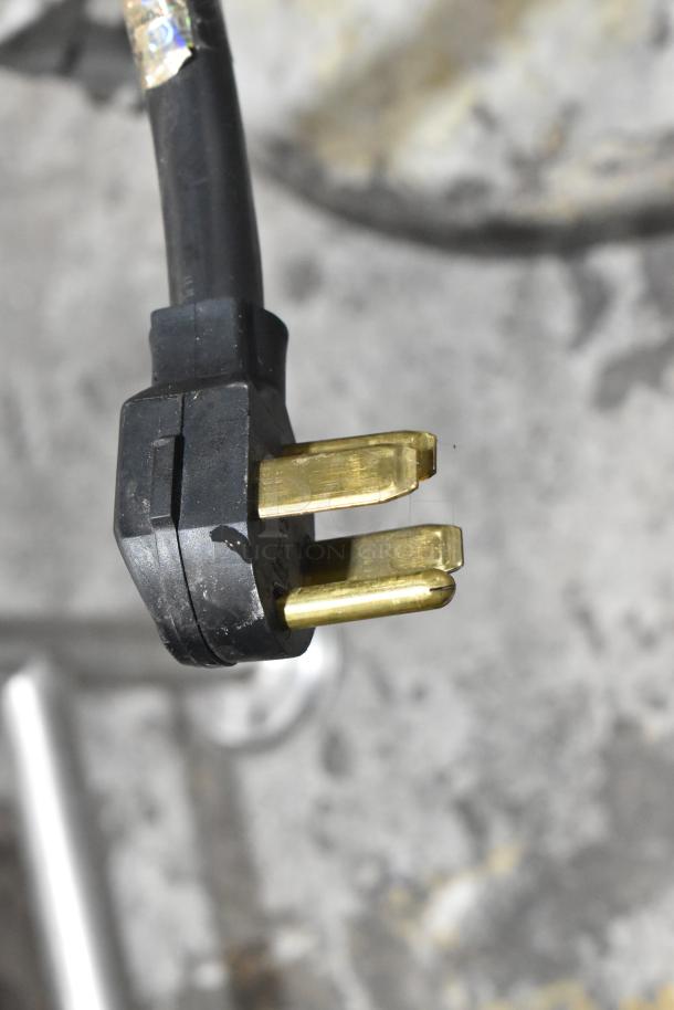 Close-up of a plug for a Hobart S-601 60 Quart Planetary Dough Mixer, showing three prongs for 208 volts, 3-phase power.