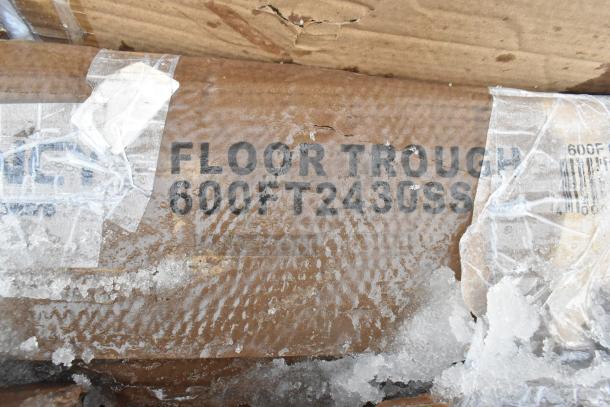 Cardboard box with "FLOOR TROUGH 600FT2430SS" label, covered in ice, showing item description and code.