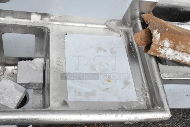 Regency 600S21014216 stainless steel 2 bay sink with dual drain boards; scratch and dent condition, visible protective coating.