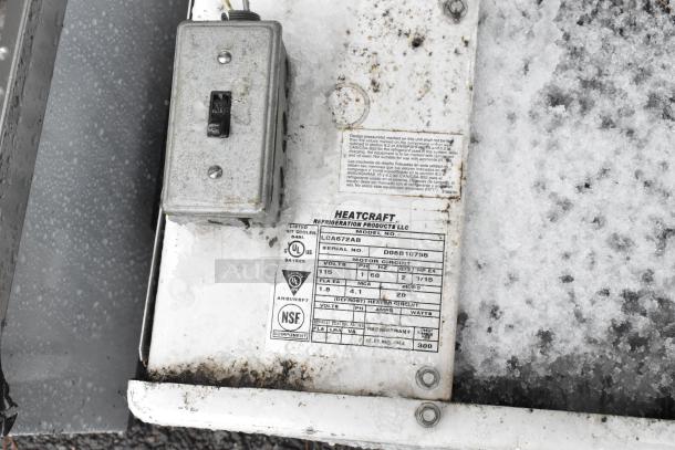 Heatcraft LCA672AB evaporator fan, 115V, 1 phase, with specifications label, snow-covered surface, visible electrical box.