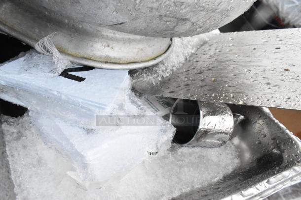 Metal colander atop ice-covered surface with visible pan rack. Includes various items like drop-in bin. Auction for 8 items.