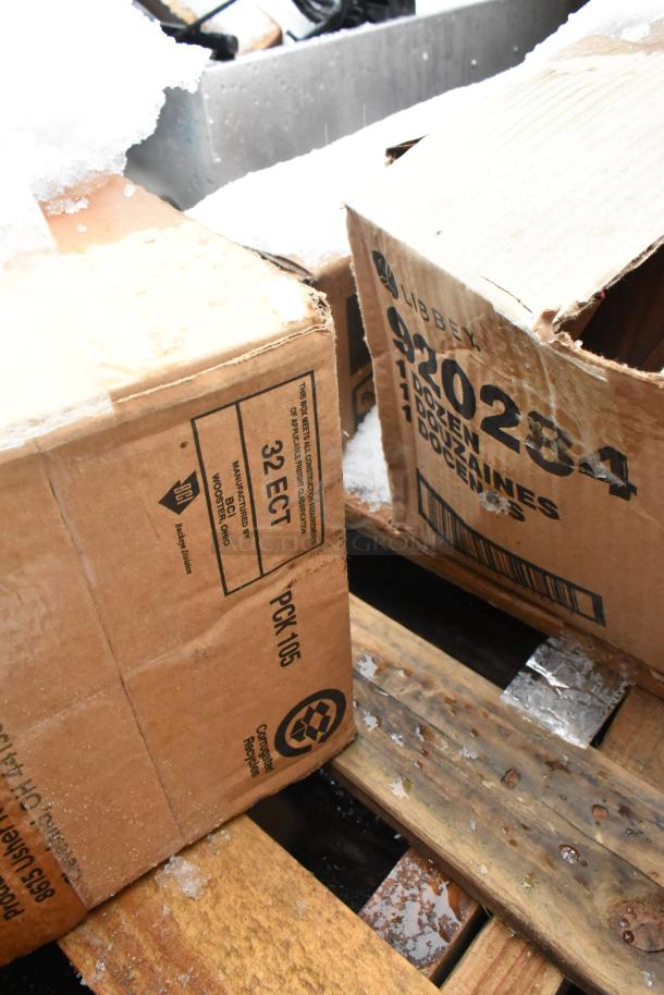 Cardboard boxes on a wooden pallet labeled "Libbey 920284," containing scratch and dent items, covered in snow.