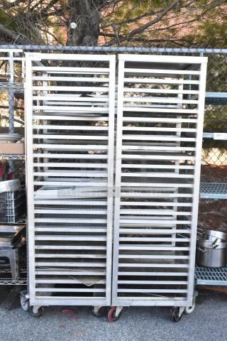 Two metal commercial pan transport racks with casters, used condition, ideal for kitchen or catering use.