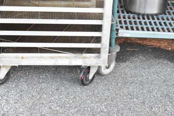 2 metal commercial pan transport racks on heavy-duty casters, showing minor wear, ideal for kitchen transport.