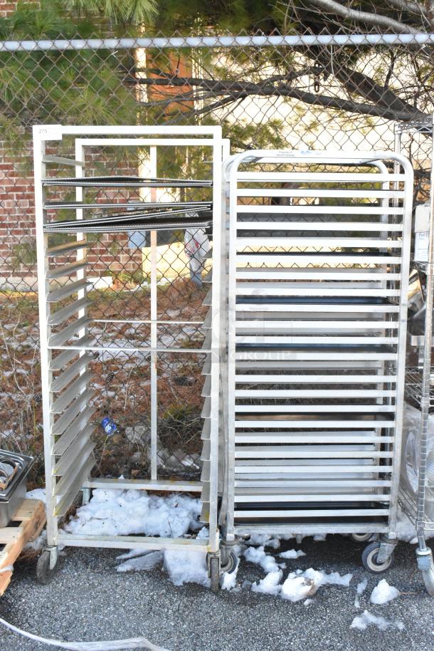 Two metal commercial pan transport racks with multiple horizontal slots, mounted on durable commercial casters.