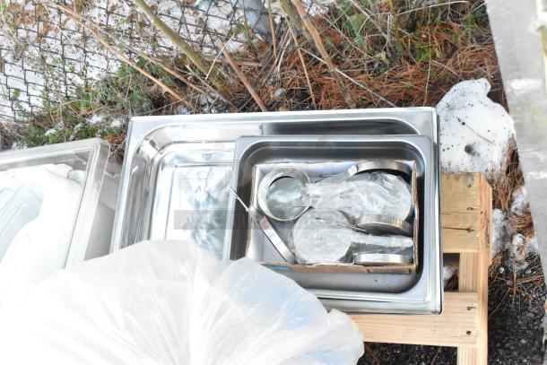 9 items including 4 Rubbermaid white poly ingredient bins, metal drop-in bins, and measuring spoons on a wooden pallet.