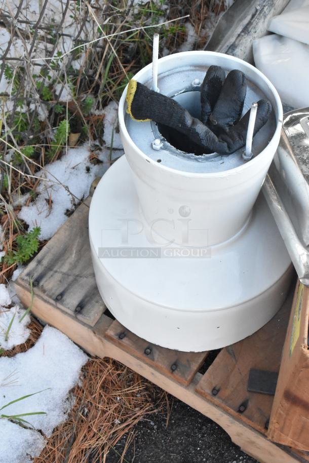 Various items including a white poly bin and chafer lid on wooden pallets, outdoor setting, lightly snow-dusted.
