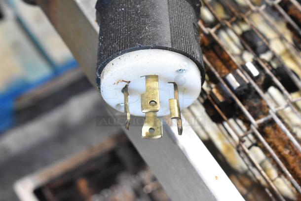 Close-up of a plug from a Middleby Marshall CTX DZ33I conveyor pizza oven, showcasing a three-prong design.