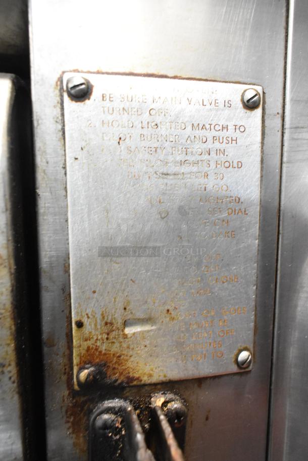 Blodgett stainless steel commercial gas pizza oven with instructions plaque, visible wear, and cooking stones.