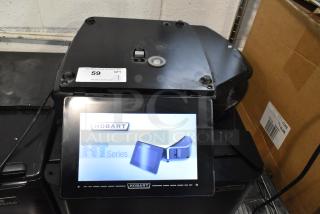 Hobart HTi-LH metal countertop scale with label printer. Missing plate, no power cord. Tested and working. Model shown on display.