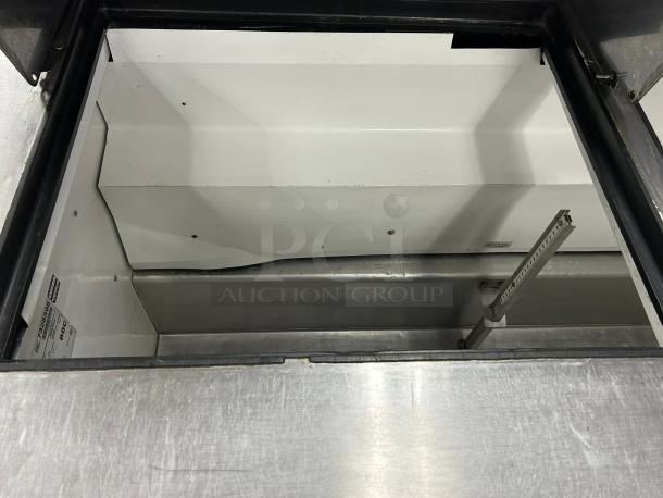 True TSSU-60-24M-B-ST-HC Mega Top Sandwich/Salad Prep Table interior, stainless steel, excellent condition, visible model label.