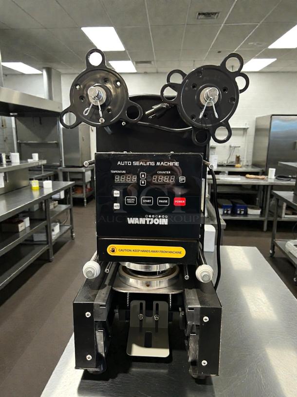 WANTJOIN cup sealing machine, model WZ-95B, 110-120V, tested and working. Features digital display, caution label, in good condition.