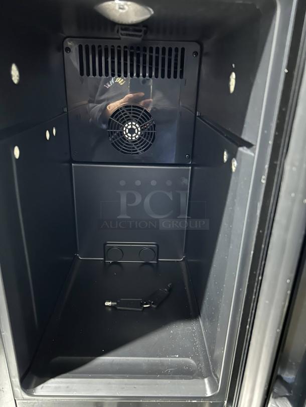 Like new countertop black refrigerator, includes plug and keys, pristine interior, visible fan and plug socket.