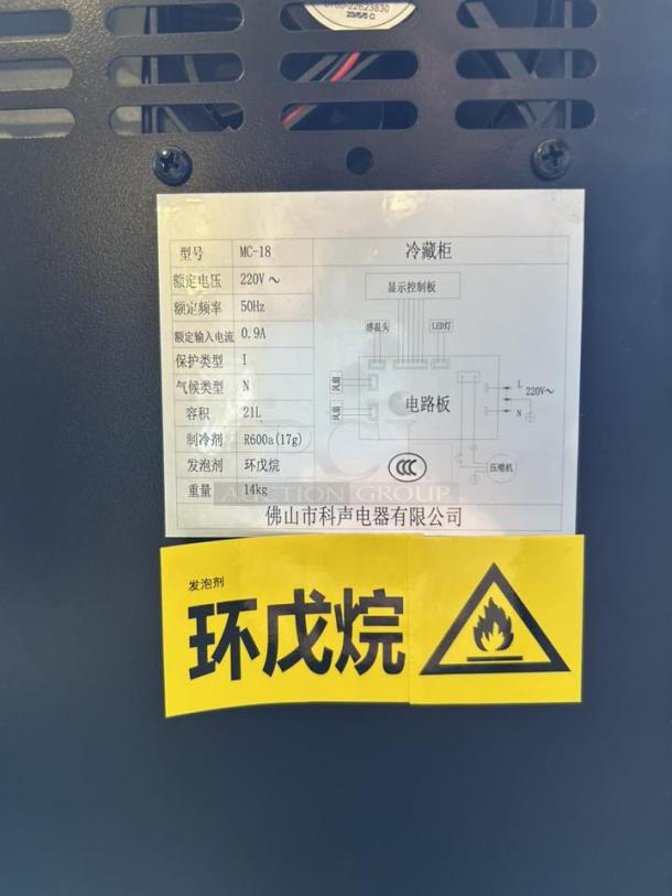 "Countertop black refrigerator, model MC-18, 21L capacity, like new. Includes plug, keys, and safety label. Voltage: 220V."