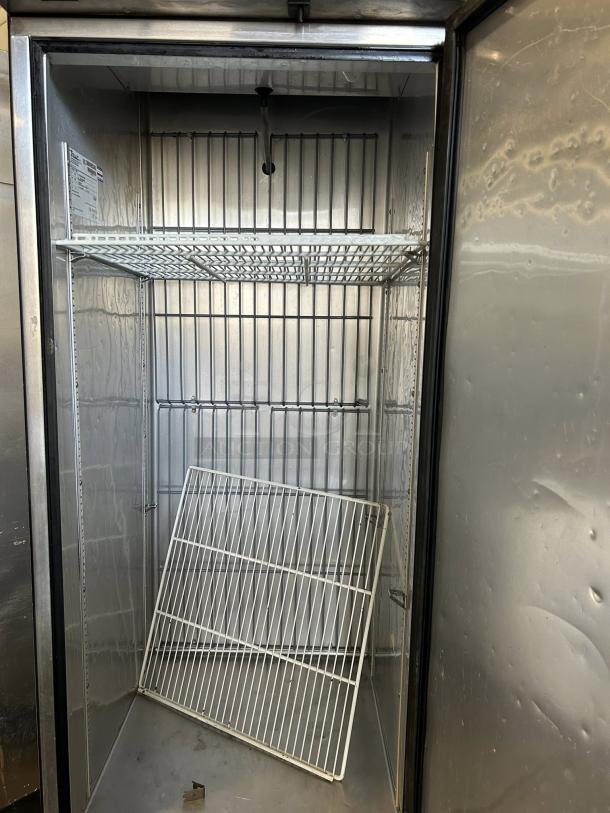 True TS-23F-HC 23 Cu.Ft commercial freezer with solid stainless door, tested, working condition, visible interior shelves.