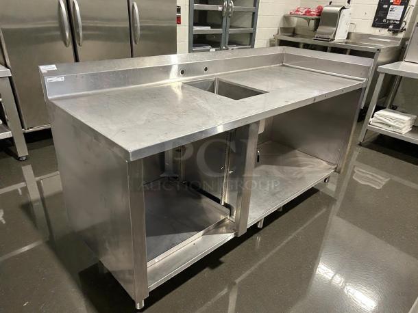 Winholt stainless steel worktop table with hand sink and backsplash in excellent condition; features open shelving and robust design.