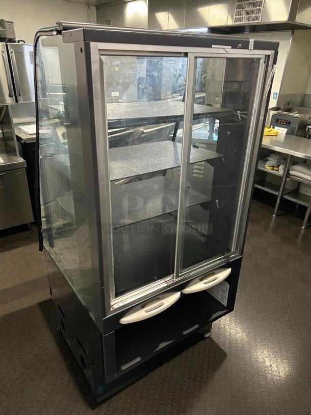 STRUCTURAL CONCEPTS Model S82755 27” curved bakery dry display case, glass doors, shelf interior, tested and working.