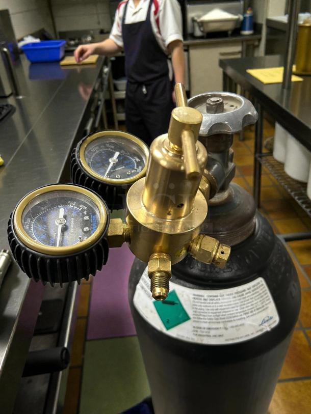 Linde UN1066 nitrogen gas cylinder with dual gauges and brass valve, in great condition. Labels detail safety and usage.