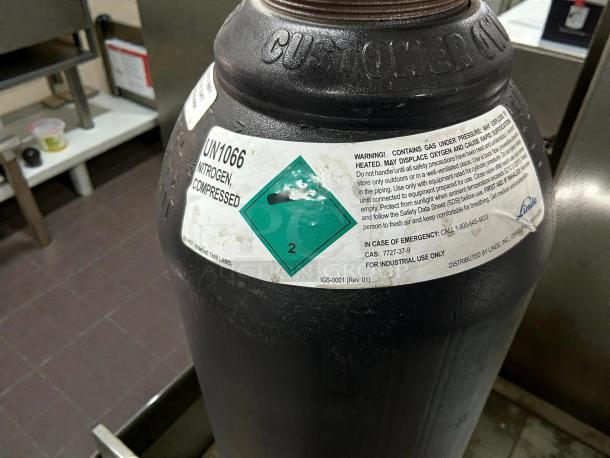 Linde UN1066 nitrogen gas cylinder, great condition, industrial use, labeled with safety warnings and emergency contact details.