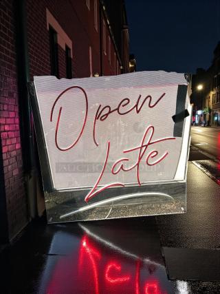 Red neon "Open Late" sign, 30"x30", in great condition. Features clear, bold lettering with reflective quality.