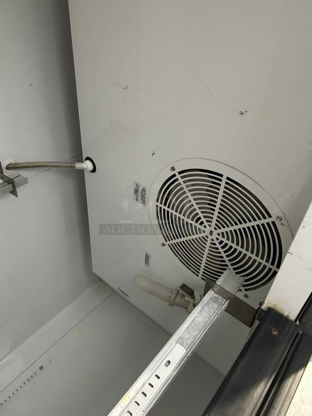 True T-49F-HC reach-in freezer interior view, showing fan and shelving supports. Freezer in great condition.