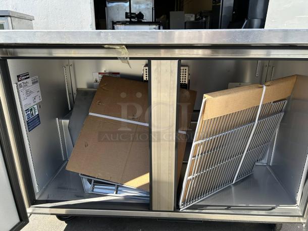 True TUC-48-HC undercounter refrigerator, new condition, interior view showing shelving and labels indicating model and efficiency.